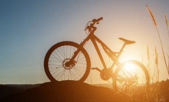 Silhouette Mountain biking on the rock at sky sunset